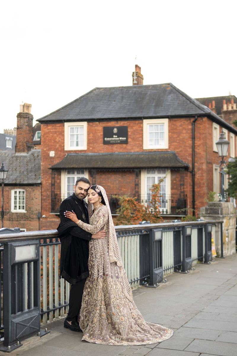 Bride and groom embracing outside a period building