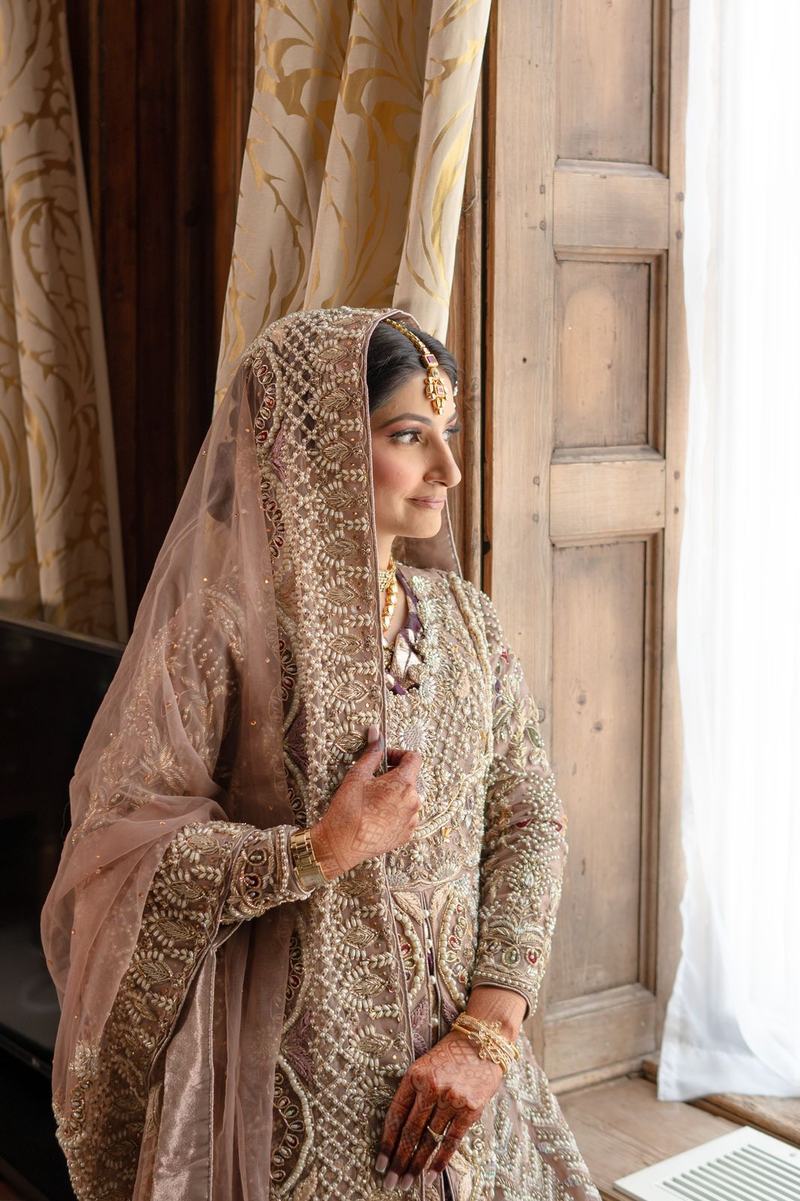 Bride portrait beside a window in ornate bridal wear