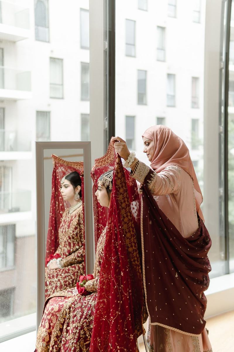 Mother adjusting brides veil in getting ready moment