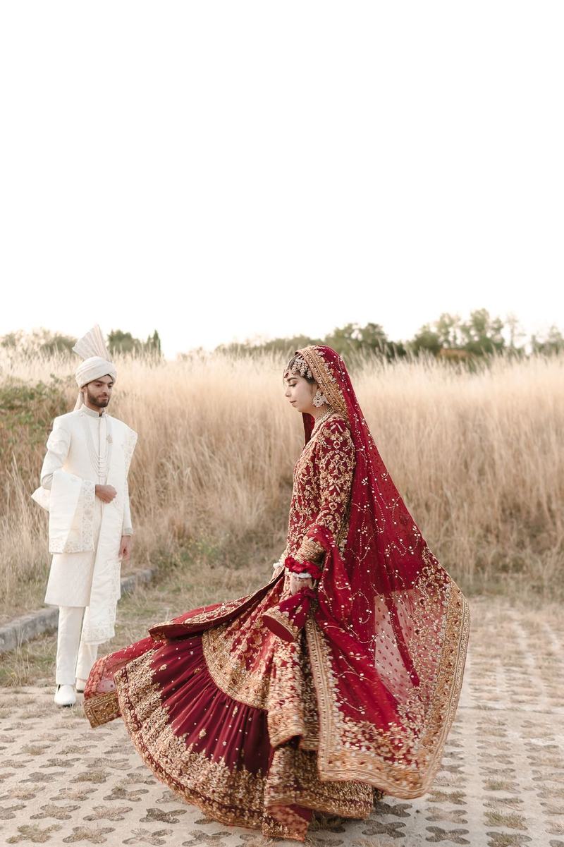 Bride twirling her red lehenga outdoors