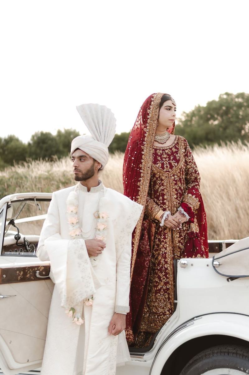 Bride and groom beside vintage car close up