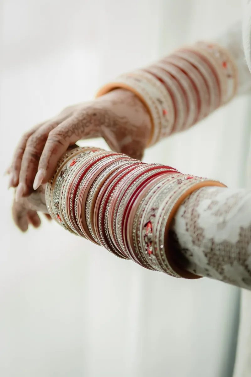 Close up of the bride's red and ivory bangles and henna