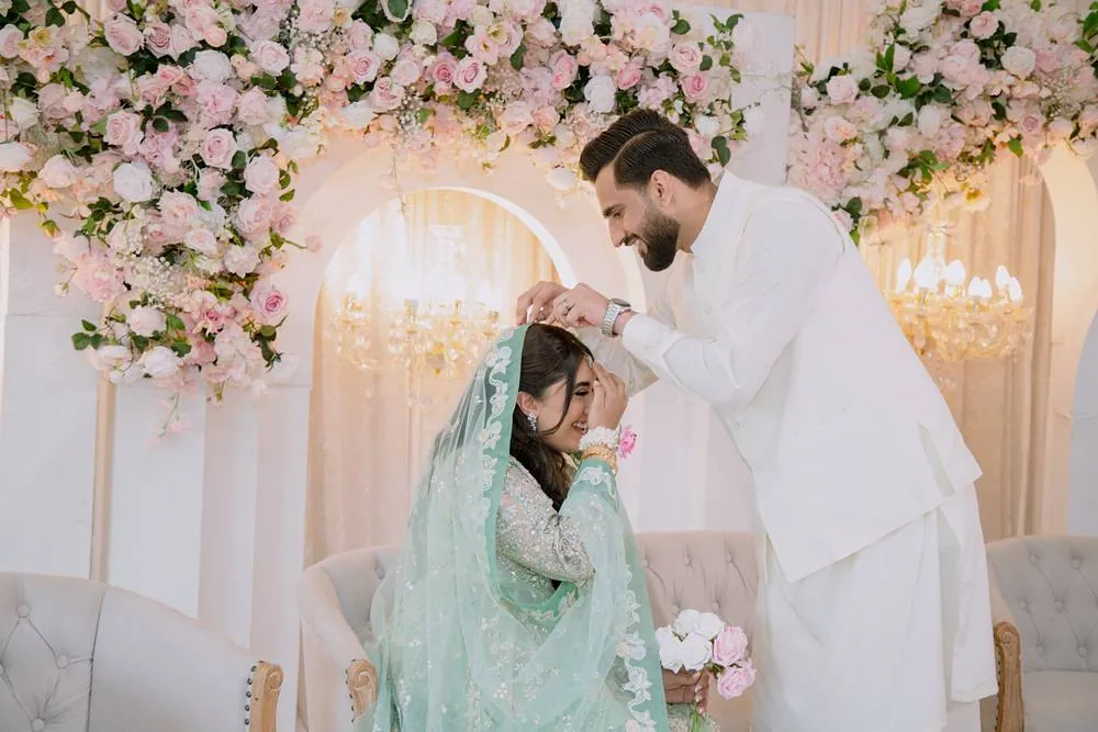 He adjusts her dupatta as she laughs