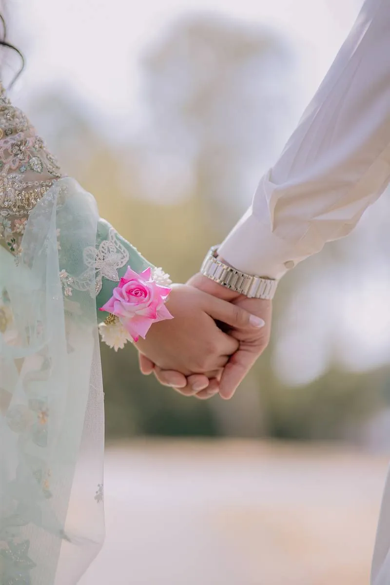 Hands held, a pink rose corsage