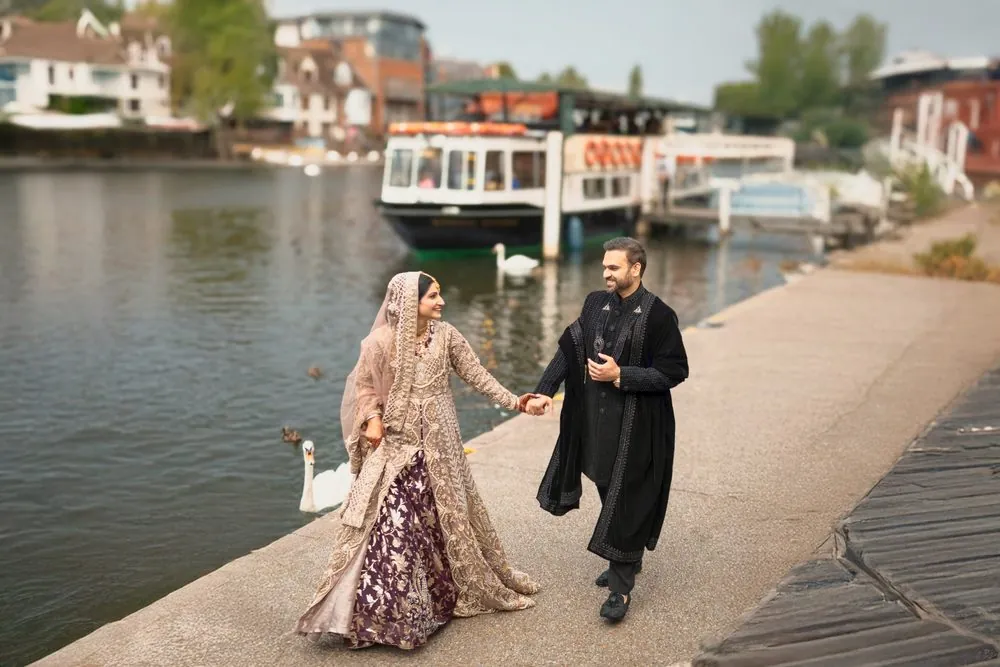 Hand in hand along the river, swans gliding by