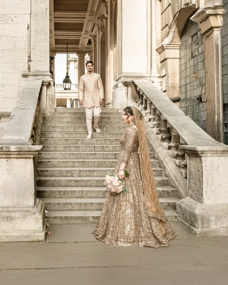 The groom walking down the stone steps towards his bride