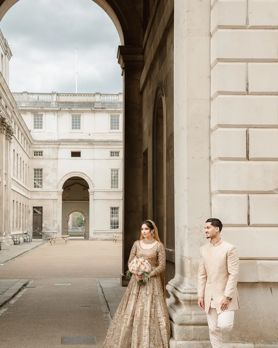 The couple beneath the great arch, the courtyard behind them
