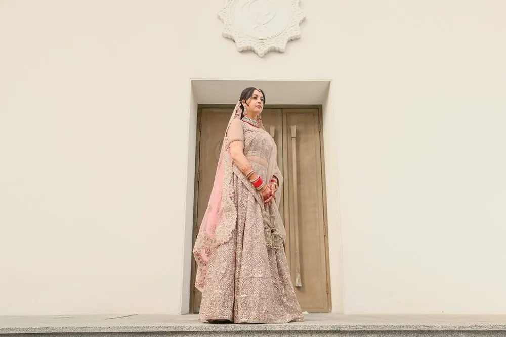 Suwati in her blush lehenga at the Gurdwara doors