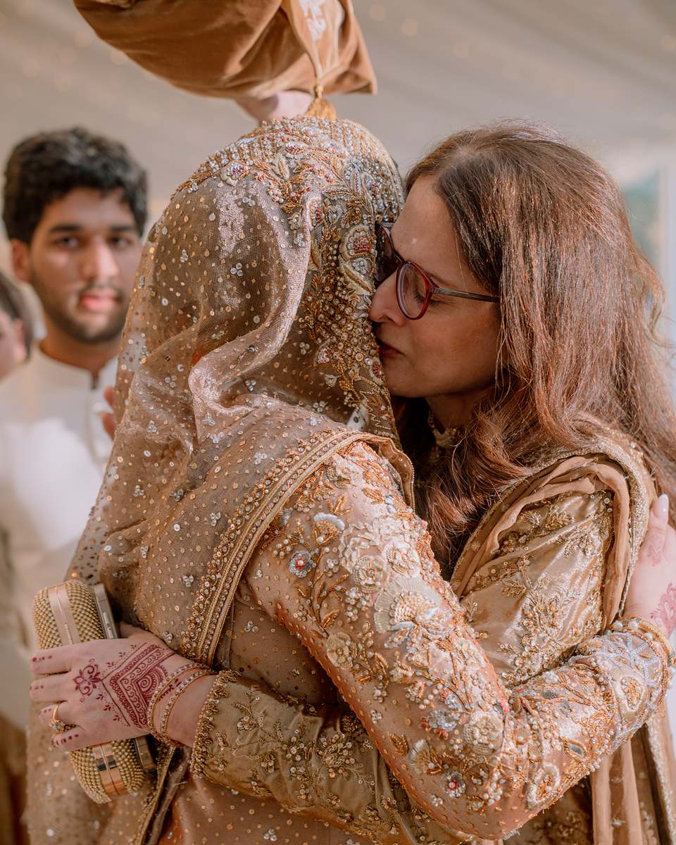 The bride held close by her mother on the morning of the Nikah