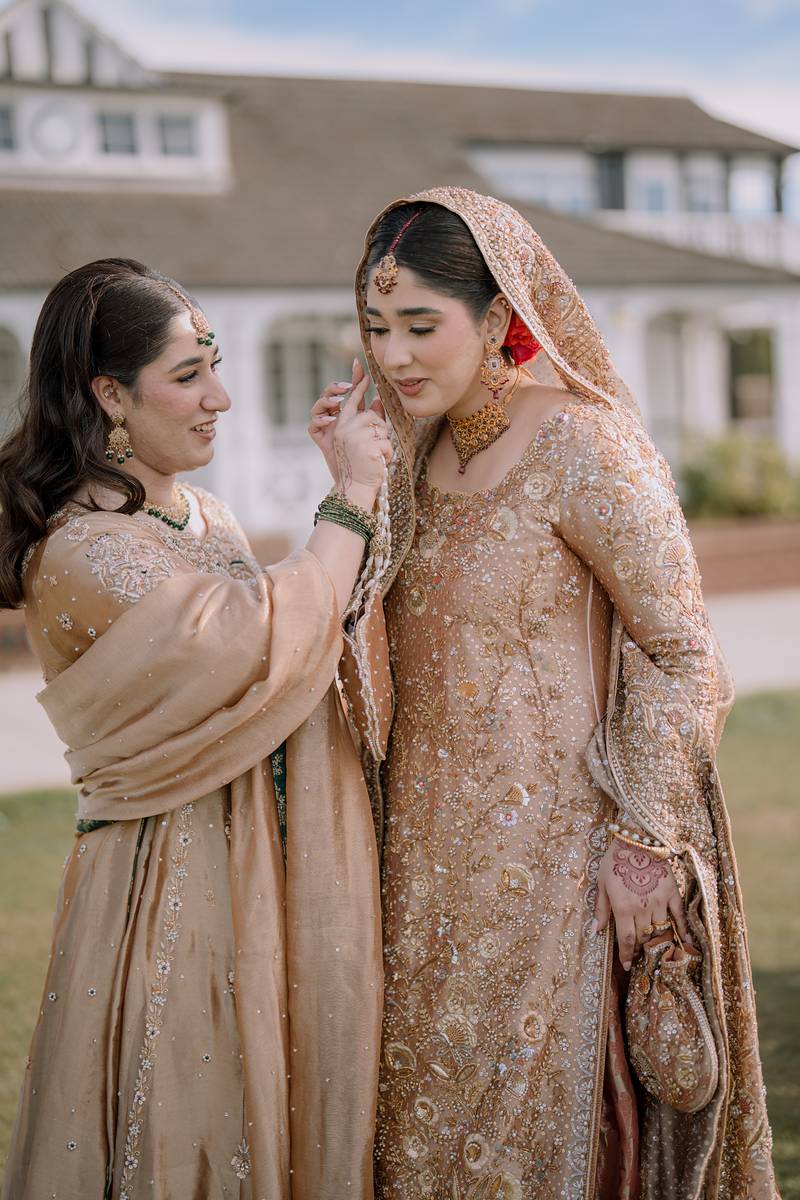Her sister fixes the dupatta one last time