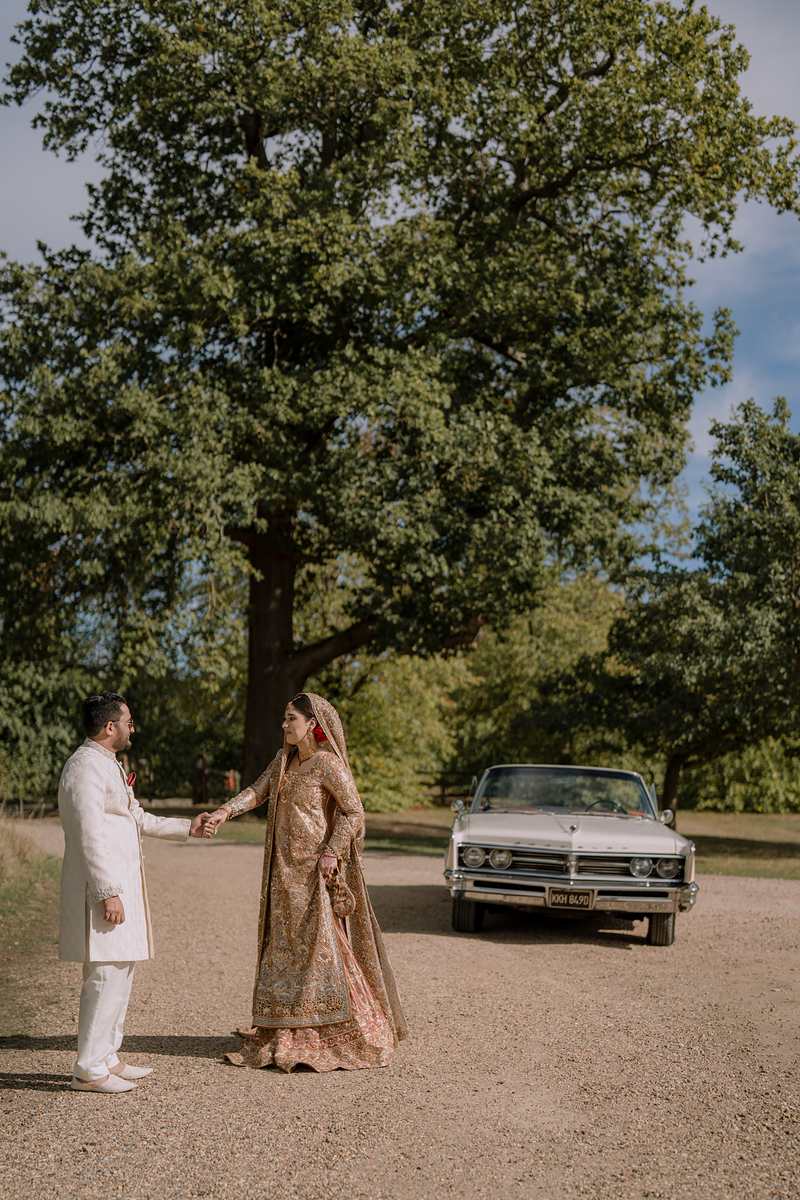 Walking towards each other beside the vintage car
