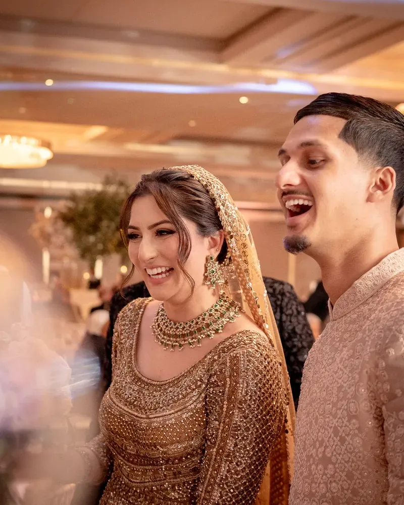 The bride and groom laughing together inside the ballroom