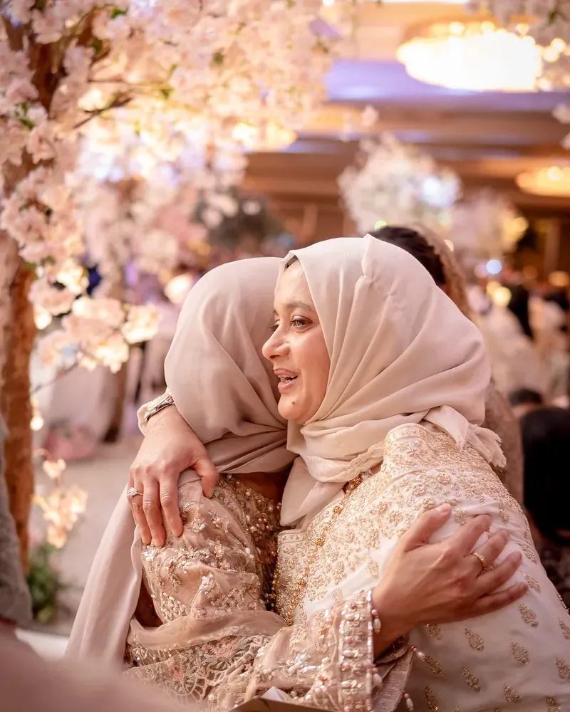 A warm embrace between family beneath the cherry blossom
