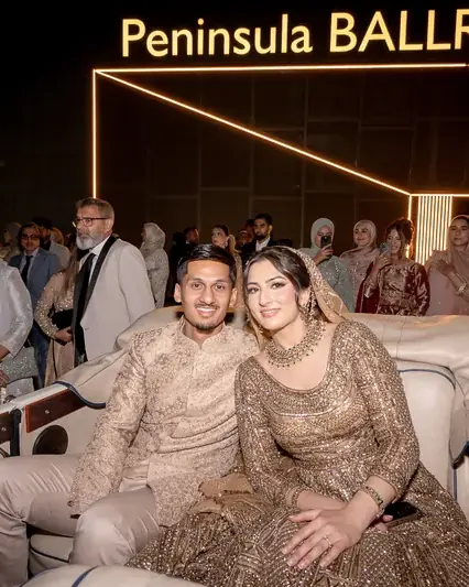 The couple in a vintage car outside the Peninsula Ballroom