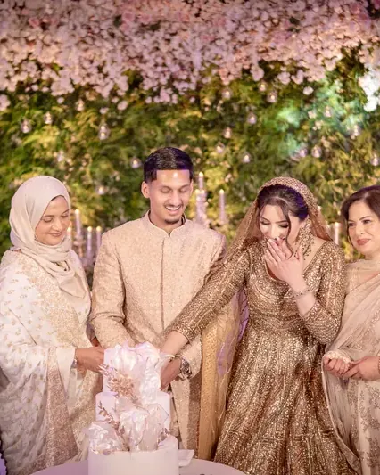 The couple cutting the cake with both families beside them