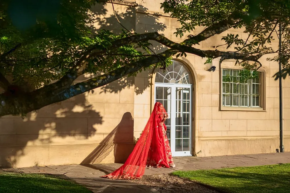 The bride in red, framed by evening light and shadow