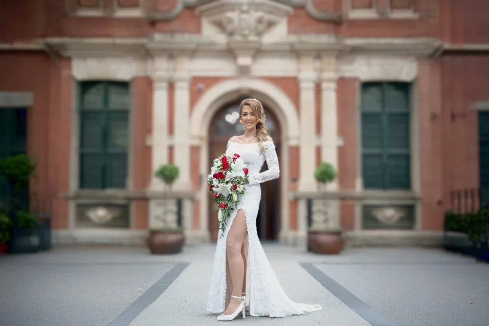 Yara in lace and red roses at the town hall steps