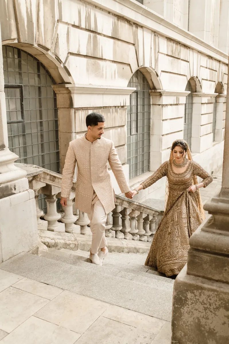 Groom leading the bride up historic stone steps